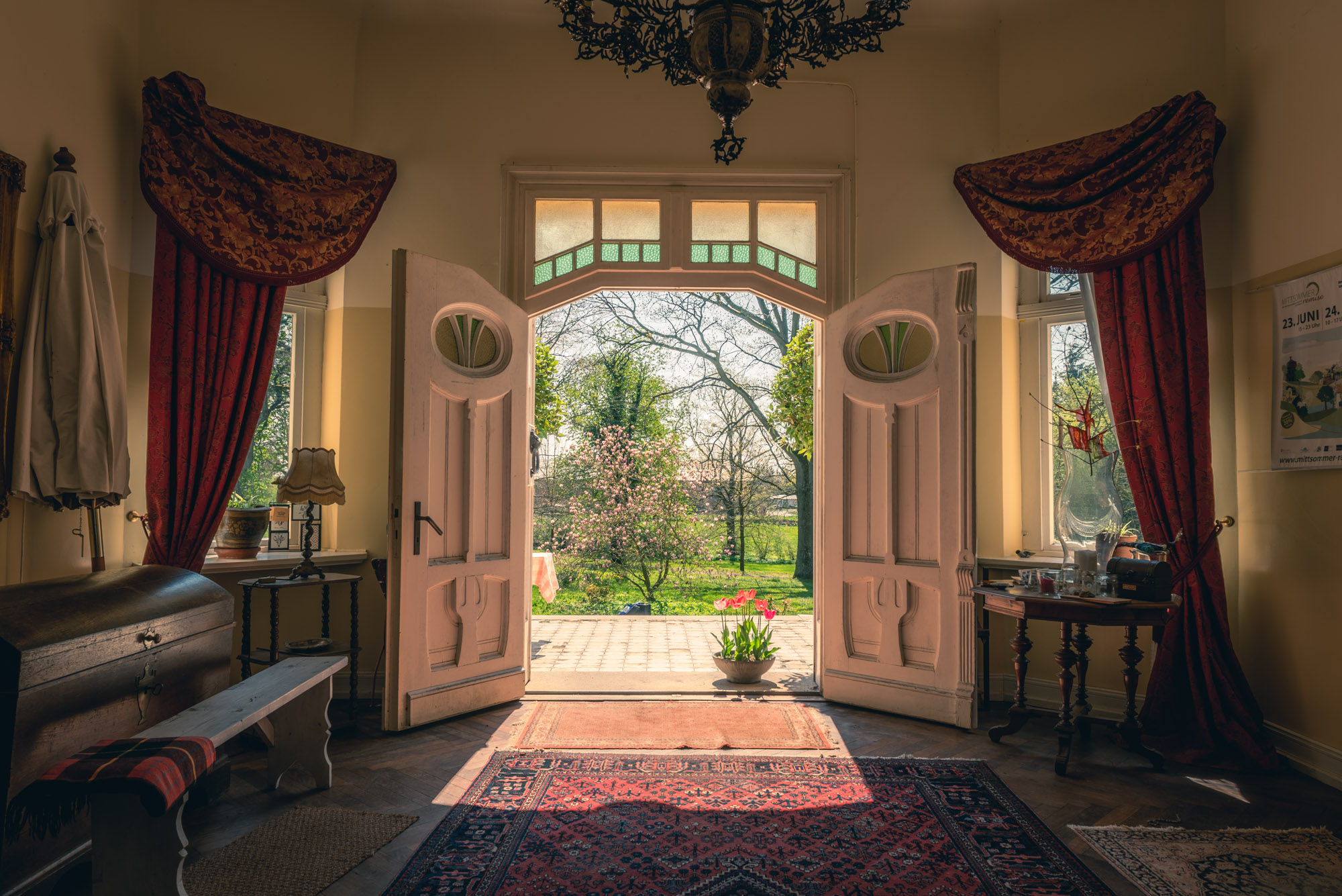 Blick aus dem Eingangsbereiches des Gutshauses Belitz nach draußen im Frühling.